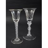 Two Georgian design drinking glasses with inverted bell-shaped bowls, one bowl engraved leaves, on