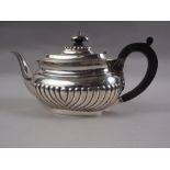 A silver half-fluted teapot with composition handle, 22.2oz troy gross