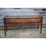 An 18th century oak plank top dresser base, fitted three drawers, on square taper supports, 72" wide