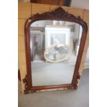 A carved and polished as mahogany arch top overmantel mirror with scroll crest, plate 22 1/22 x 34"