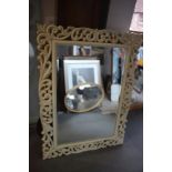 A cream painted open scrollwork framed wall mirror, bevelled plate 23" x 35"