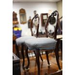 A pair of Victorian carved walnut loopback side chairs with stuffed over seats, on cabriole supports