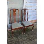 A set of four oak, chestnut and fruitwood side chairs of Queen Anne design with vase splats and