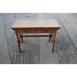 A late 19th century Aesthetic Movement oak desk, fitted two drawers, on turned and stretchered