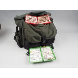 A green fishing bag, containing a large collection of flies, etc