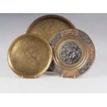 An Indian brass, copper and white metal mounted dish with relief decoration of a deity and