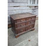 An early 18th century oak chest of two short and two long drawers with fielded panel fronts and