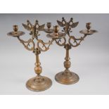 A pair of Eastern European? brass candelabra with griffin design, on circular bases, 16" high