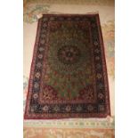 A Qum silk rug with floral elephant guls, central medallion and triple guarded blue borders