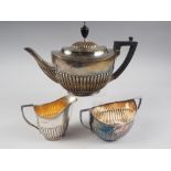 An early 20th century three-piece silver teaset with fluted decoration (teapot engraved), 29oz