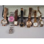 A lady's Gucci wristwatch with leather strap, a lady's Fossil watch with brilliant set bezel, a