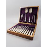 A set of silver plated engraved fruit knives and forks, in oak fitted case, serving spoons and a nut