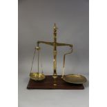 A set of W & T Avery brass balance scales, on mahogany base, 22" high