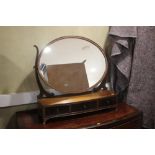 A Sheraton revival mahogany framed oval toilet mirror, on plateau base, fitted three drawers, 27"
