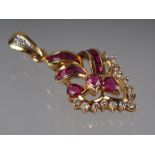 A Thai yellow metal scrollwork pendant, stamped 750, set rubies and diamonds, 4.3g gross