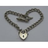 A silver charm bracelet having hallmarked heart padlock clasp,