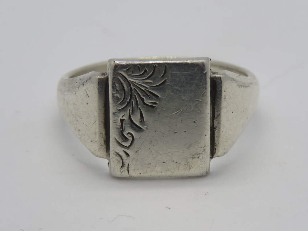 A HM silver mens signet ring having central unengraved square shaped panel with foliate decoration
