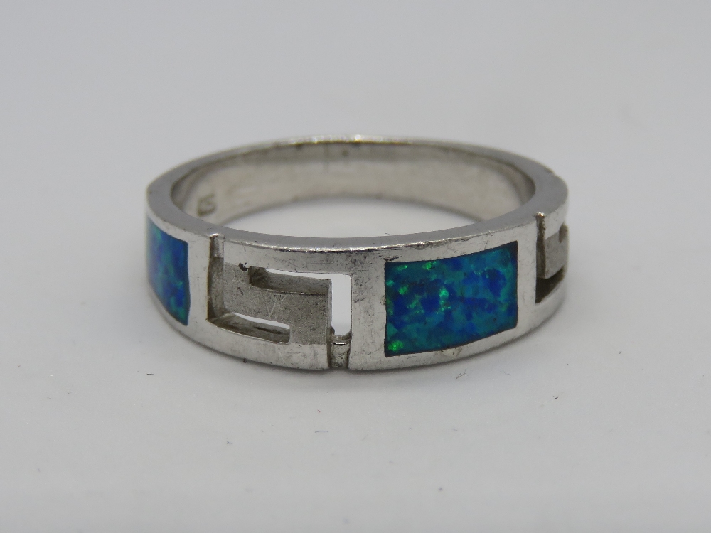A silver and opal ring with Greek key design carved panels, stamped 925, size O-P.