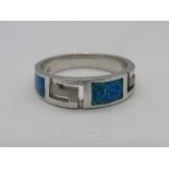 A silver and opal ring with Greek key design carved panels, stamped 925, size O-P.