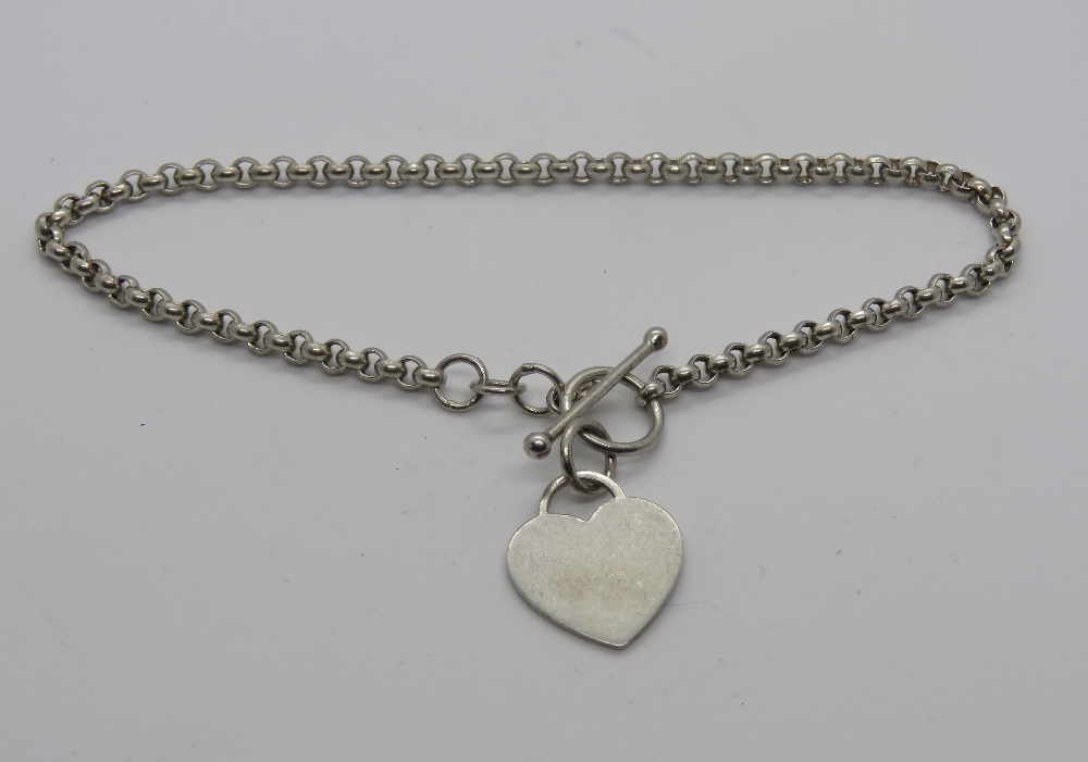 A charm bracelet having T-bar clasp and heart charm upon, stamped 925.