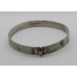 A HM silver bangle having overlapping oval pattern upon, London Jubilee hallmark upon, 5.2cm dia.
