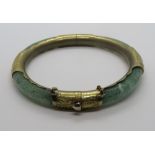 A jade bangle with gilt metal fittings, slightly a/f, 7.5cm ext dia, 6cm int dia.