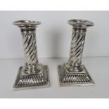 A pair of HM silver Victorian short candlesticks each having square shaped base with twist