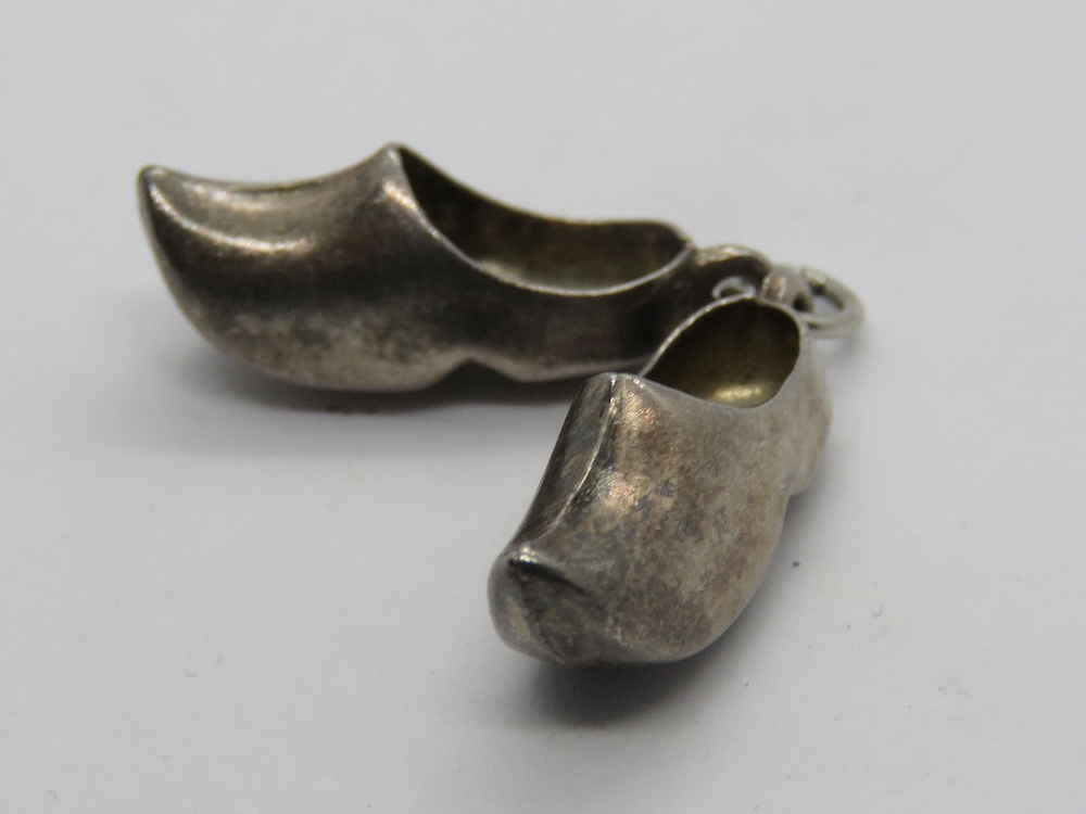 A silver charm in the form of a pair of clogs, silver hallmark upon (830?).