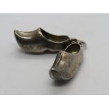 A silver charm in the form of a pair of clogs, silver hallmark upon (830?).