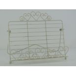 A contemporary white metal book stand having heart design, 30cm wide.