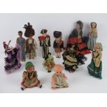 A quantity of assorted vintage dolls in traditional dress including three sleepy eyed dolls.