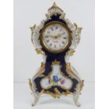A German made ceramic mantle clock in cobalt blue and white ground with gilded and foliate