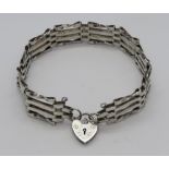 A silver four bar bracelet having hallmarked heart padlock clasp.