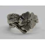 A silver floral design ring, stamped 925, size O.