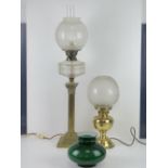 A brass oil lamp having clear glass reservoir over classical style column base,