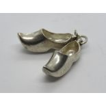 A silver charm in the form of a pair of clogs, silver hallmark upon (830?).