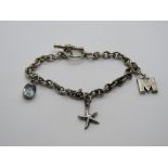 A silver charm bracelet having 925 aquamarine charm and star fish charms upon,
