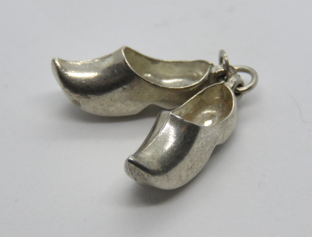 A silver charm in the form of a pair of