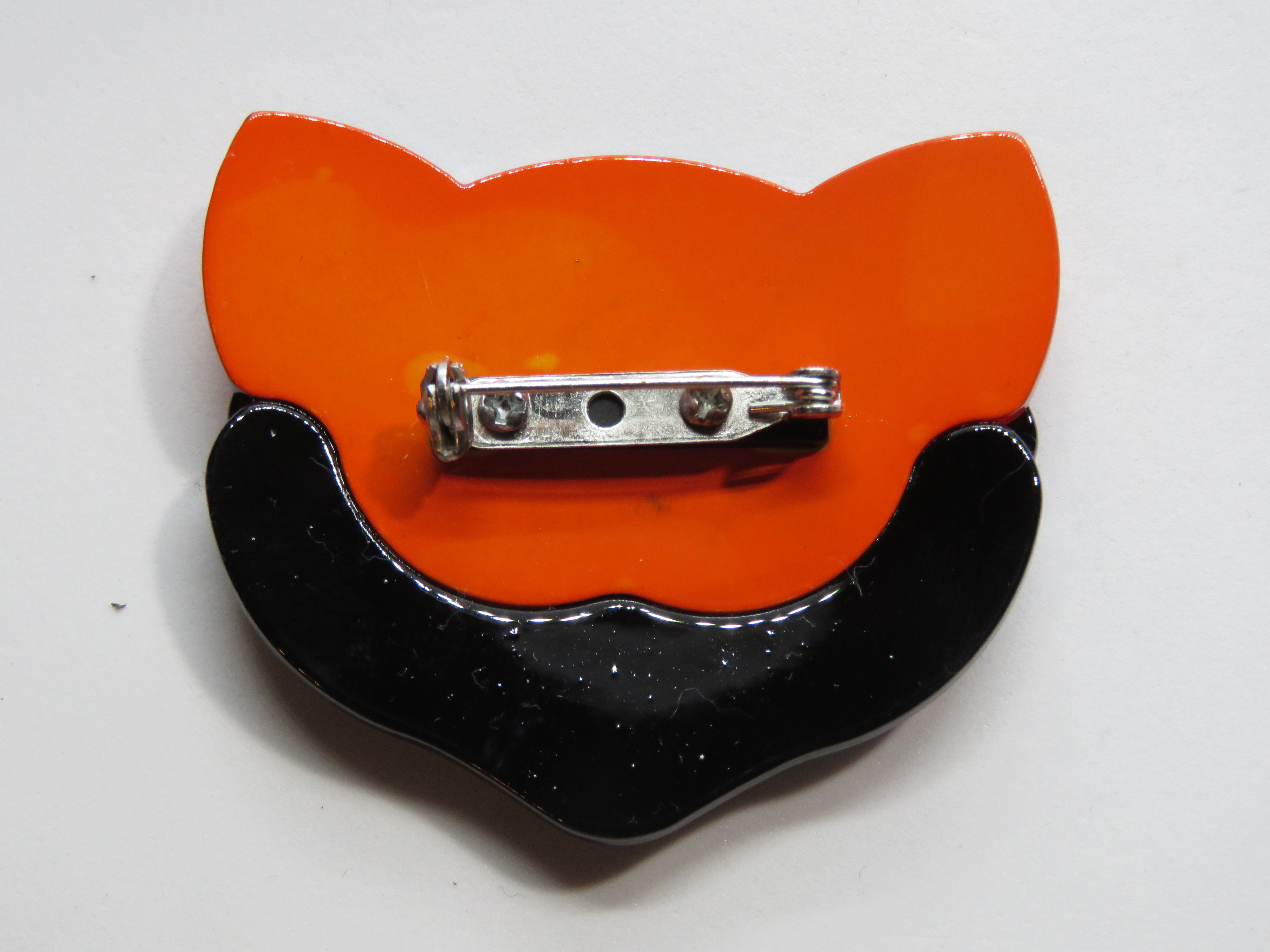 An overlaid plastic brooch in the style of Lea Stein in the form of a cats face, 5.5cm wide. - Image 2 of 2