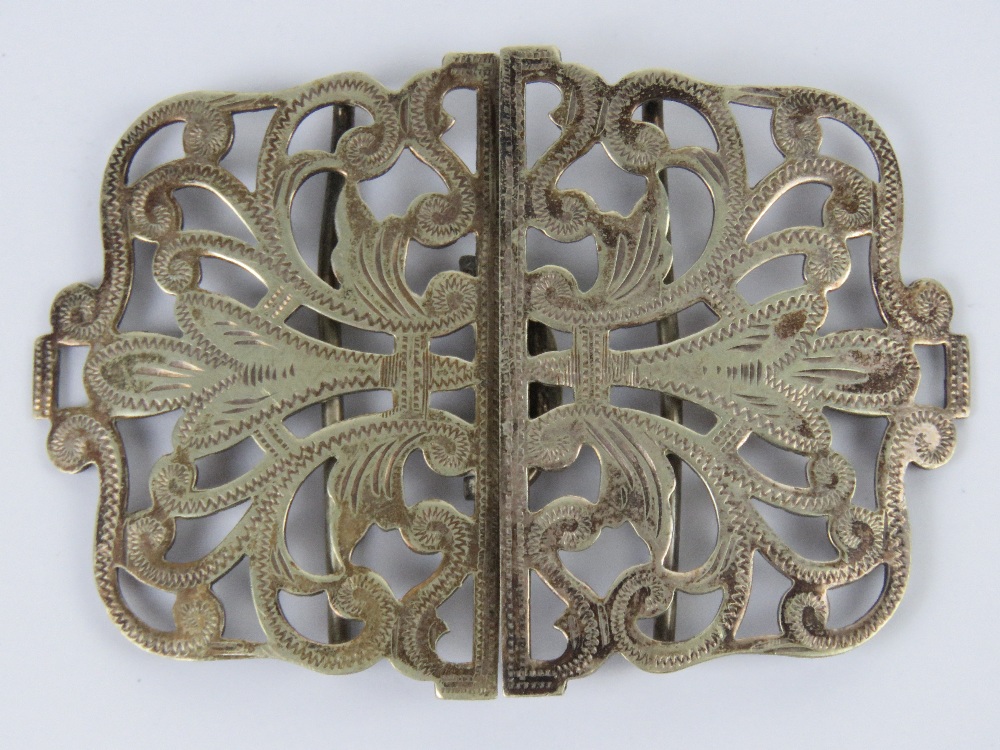 A white metal nurses buckle having scrol