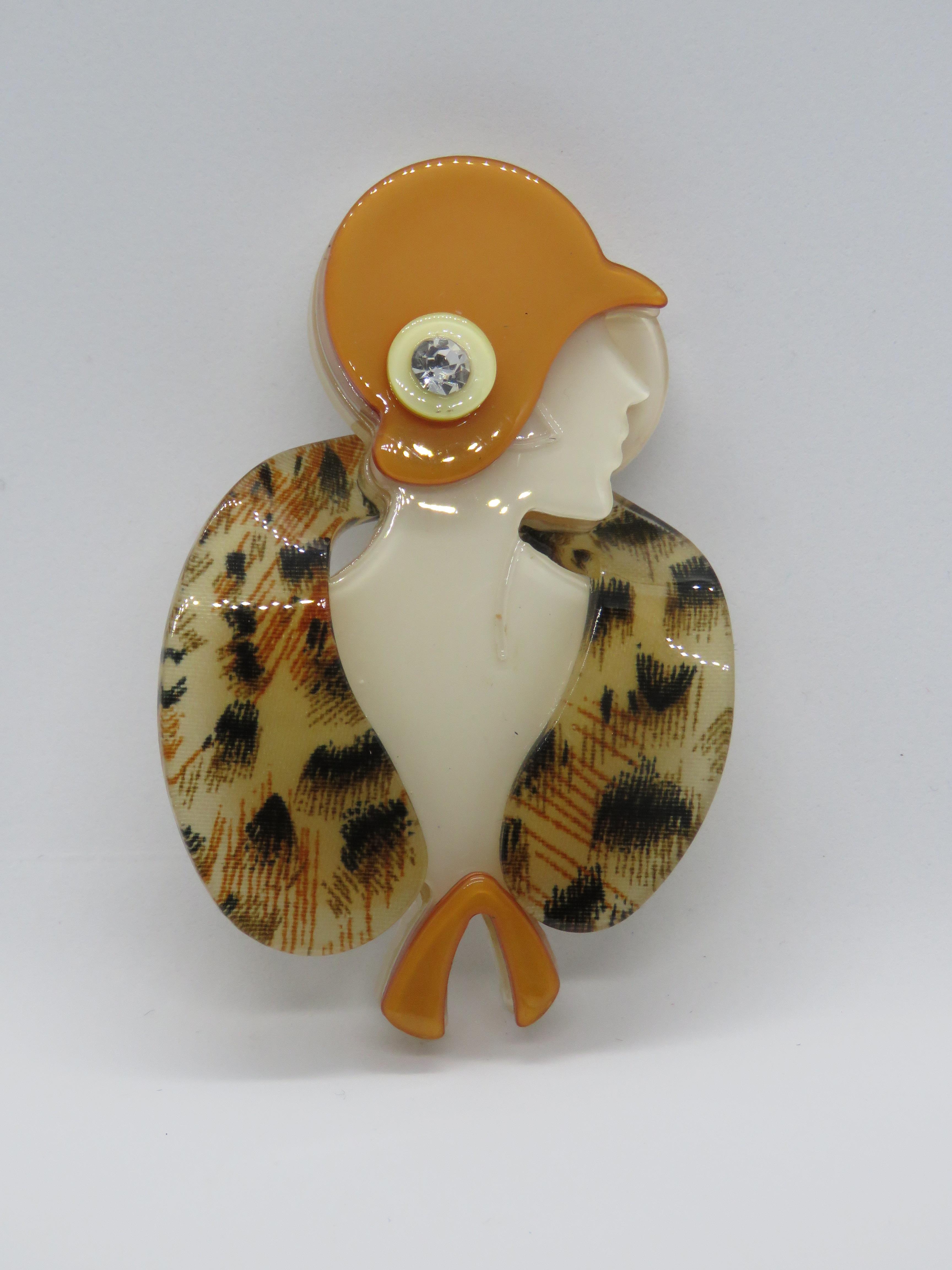 An overlaid plastic brooch in the style of Lea Stein in the form of a 1930s woman in hat and