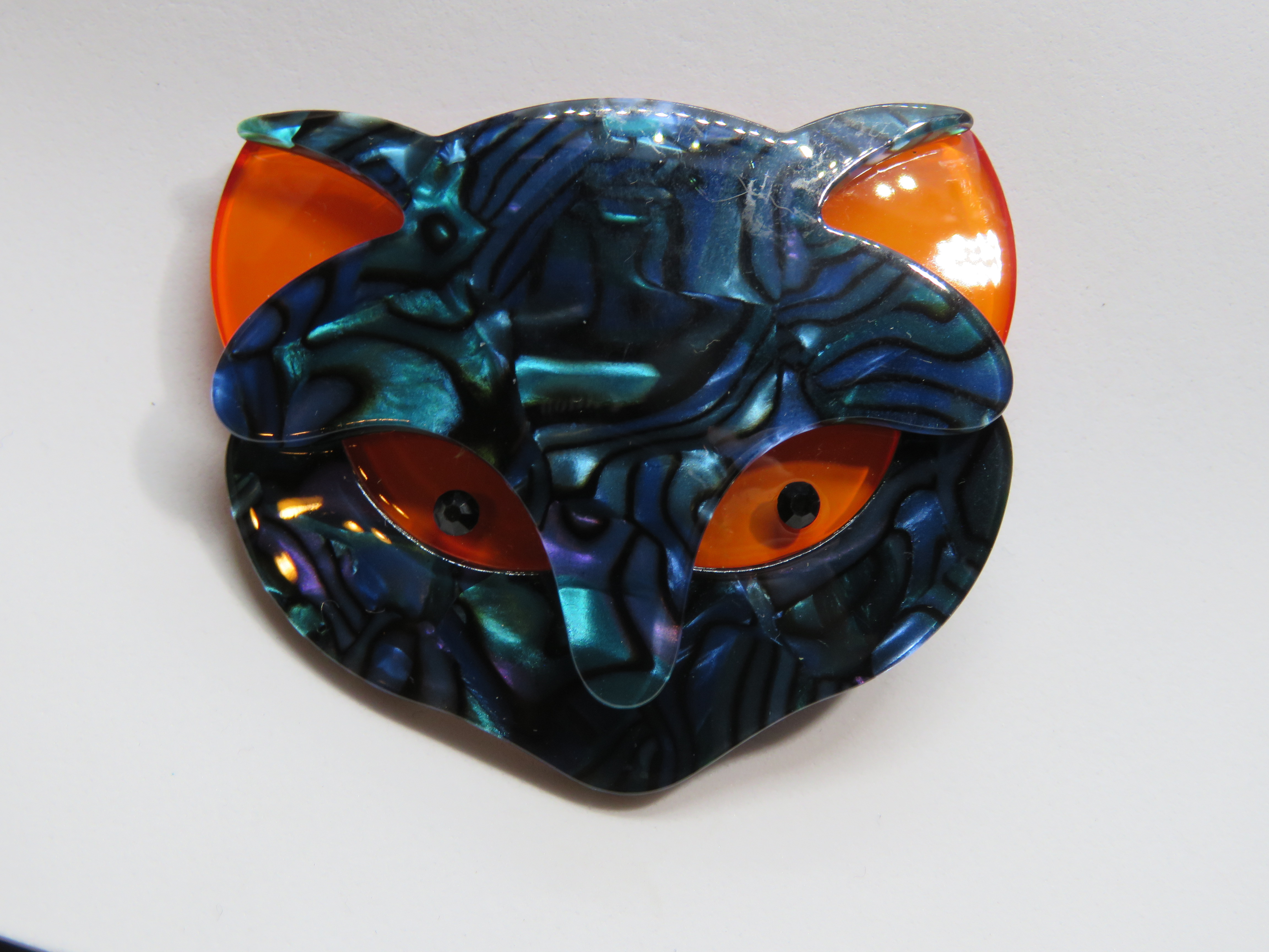 An overlaid plastic brooch in the style of Lea Stein in the form of a cats face, 5.5cm wide.