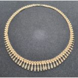 A 9ct gold articulated necklace having three-row panel chain with graduated 'tassles' upon,