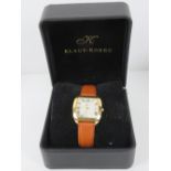 A Klaus-Kobec Charisma wristwatch on tan leather strap having cream dial with date aperture. In box.