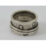 An Arts and Crafts style silver ring having large band with leaf decoration and two thinner bands