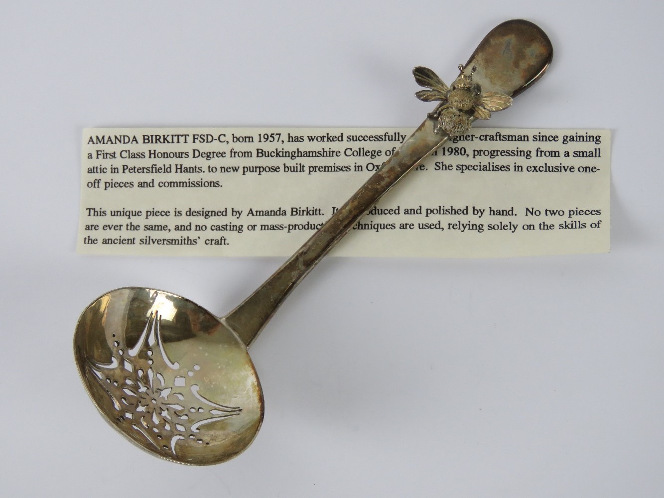 Amanda Birkett FSD-C (b1957); a HM silver sifter spoon having applied bee upon,