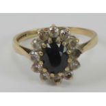 A 9ct gold sapphire cluster ring, the central blue sapphire approx 0.