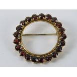 An 18ct gold and ruby brooch, stamped 750, 3.2cm dia, 8.2g.