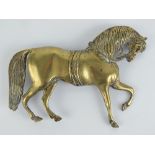 A large brass stable door plaque in the form of a horse in bridle, 28.5cm wide.