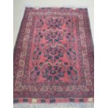 A wool and silk rug, red ground having Geometric design, 165 x 104cm.